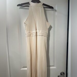 Full length pleated cream high neck dress with cross pattern and chest split